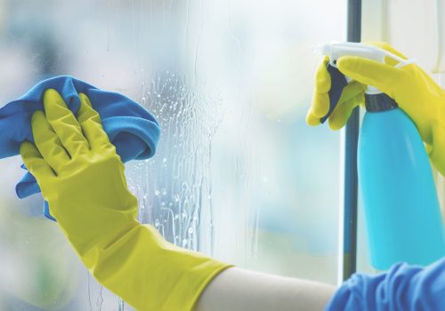 persona con guantes limpiando los cristales
